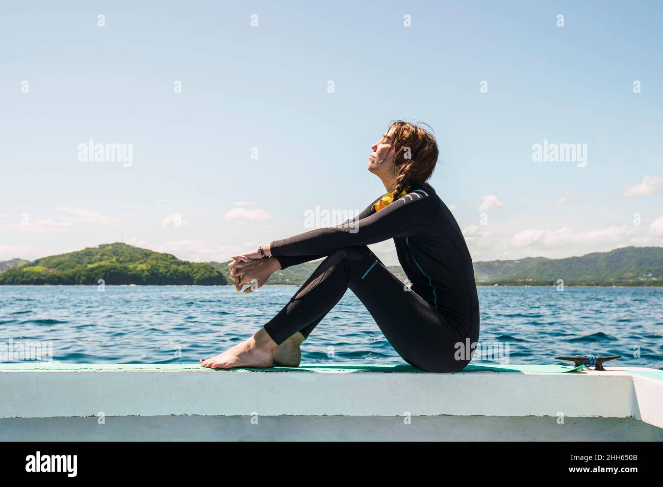Mujer joven en traje de neopreno en la playa del Coco en un día soleado  Fotografía de stock - Alamy