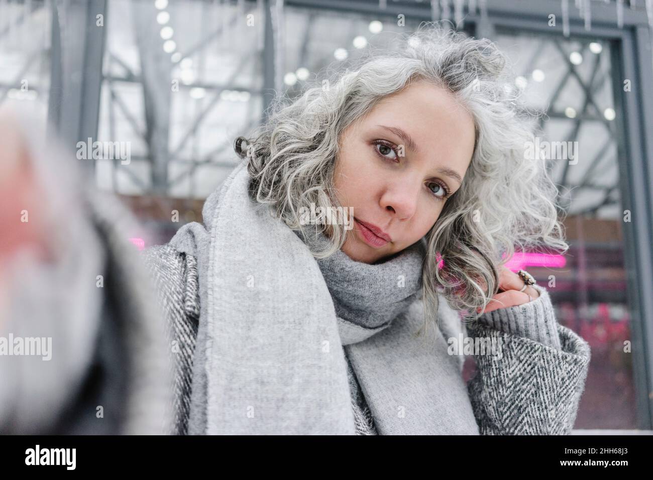 Mujer con bufanda con la mano en cabello gris Foto de stock