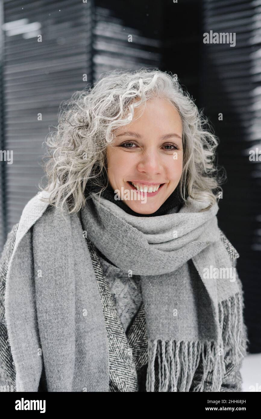 Mujer sonriente con pelo gris con ropa de abrigo Foto de stock
