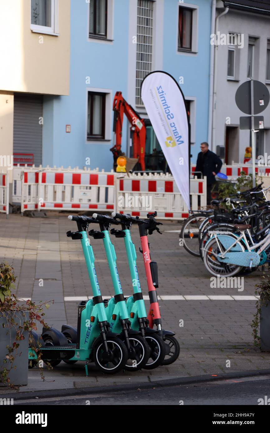 vier e-Scooter veschiedener Anbieter stehen aufgereiht am Strassenrand, Renania del Norte Westfalia, Deutschland, Köln-Rodenkirchen Foto de stock