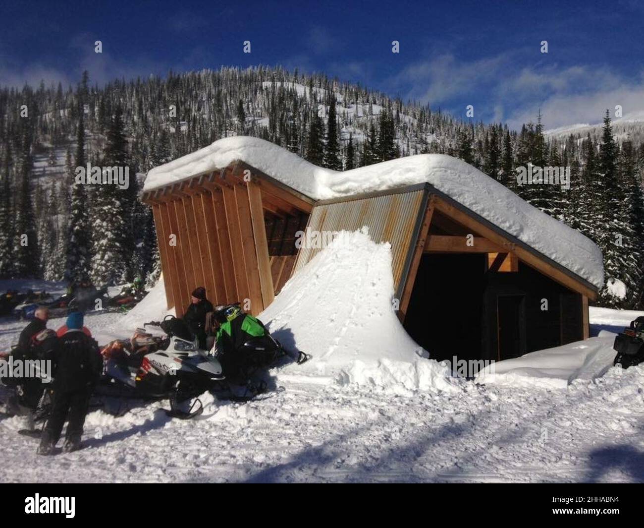 Motos de nieve fuera de una cabaña calentando (39609485705). Foto de stock