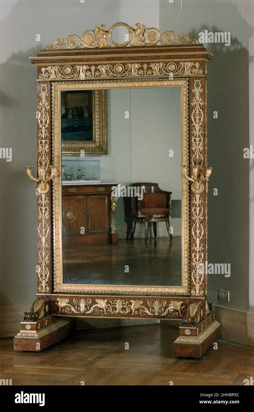 Vidrio Cheval (psique) ca. 1810–14 atribuida a François-Honoré-Georges Jacob-Desmalter francés La psiqué fue así llamada para la heroína en Les Amours de Psyché de La Fontaine, que fue reputado haber mirado una reflexión completa de sí misma. La referencia específica al mito está en el friso que contiene mariposas, símbolos de Psique. Un idéntico friso de bronce dorado fue en un psiqué hecho para la emperatriz Marie-Louise en 1810. Las dos fantásticas criaturas aladas en la cresta sostienen una corona, que probablemente originalmente contenía un motivo decorativo o monograma. Cristal de Cheval (psiqué) 195220 Foto de stock