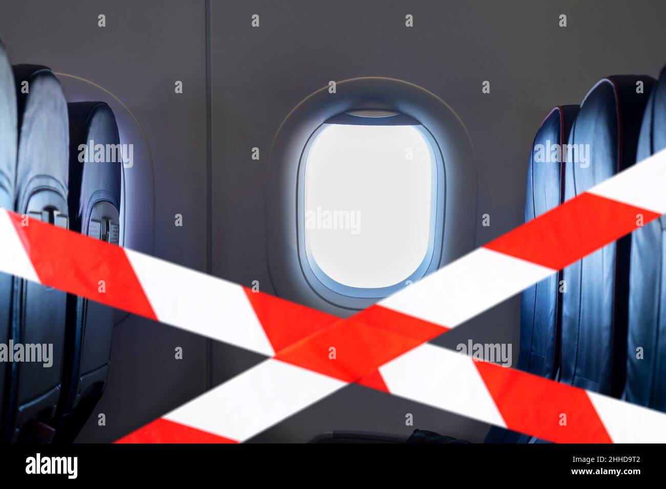 El interior vacío de un avión y la cinta roja significa no sentarse aquí, la imagen conceptual sobre la pandemia de virus en el mundo Foto de stock