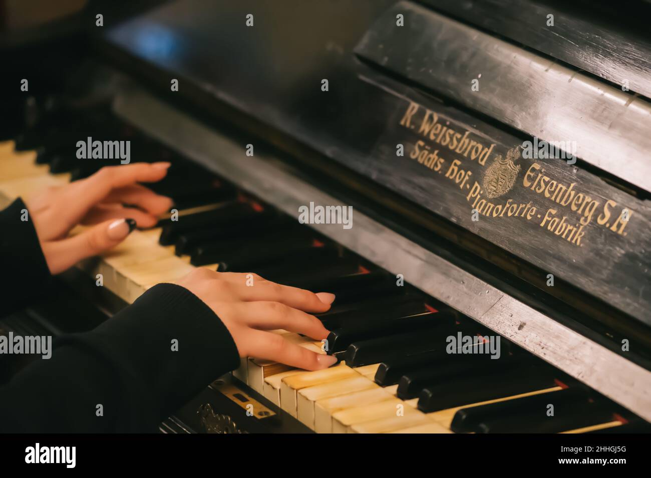 Hermosas manos con los dedos largos de una chica con clavos barnizados  negros tocando un viejo piano Weissbrod Eisenberg Fotografía de stock -  Alamy