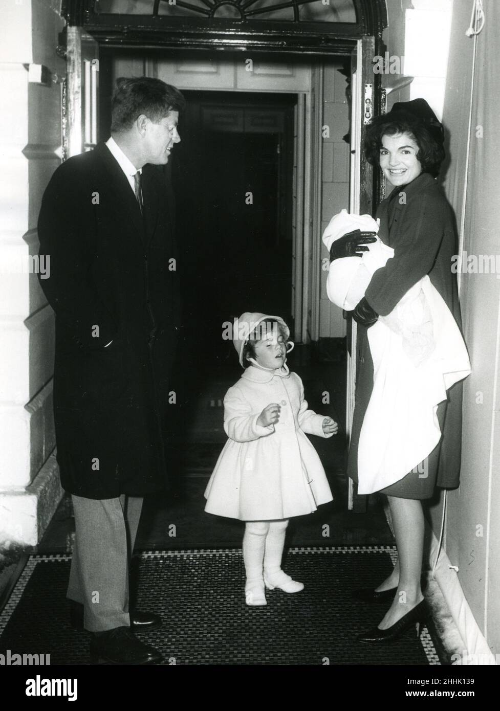 El recién inaugurado Presidente John F. Kennedy y la hija Caroline traen a la Sra. Kennedy y al bebé John Jr. A casa de la Casa Blanca desde el hospital. 4 de febrero de 1961. Abbie Rowe Fotógrafo. Foto de stock