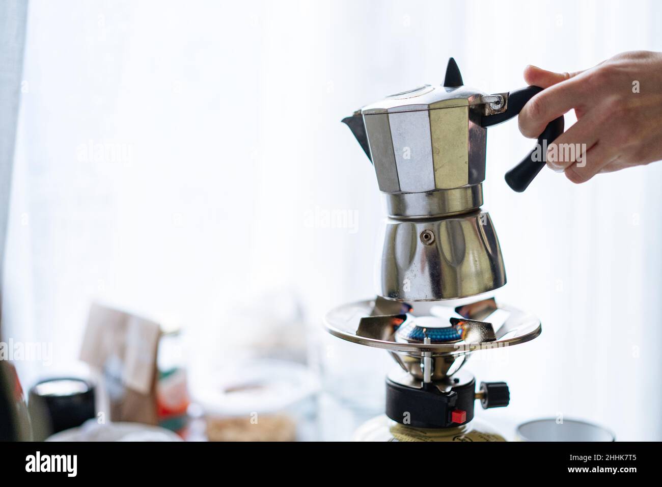 https://c8.alamy.com/compes/2hhk7t5/corta-a-una-persona-irreconocible-con-una-moderna-moka-de-metal-para-preparar-cafe-en-una-estufa-de-gas-inoxidable-en-una-cocina-ligera-con-tazas-en-un-backgroun-borroso-2hhk7t5.jpg