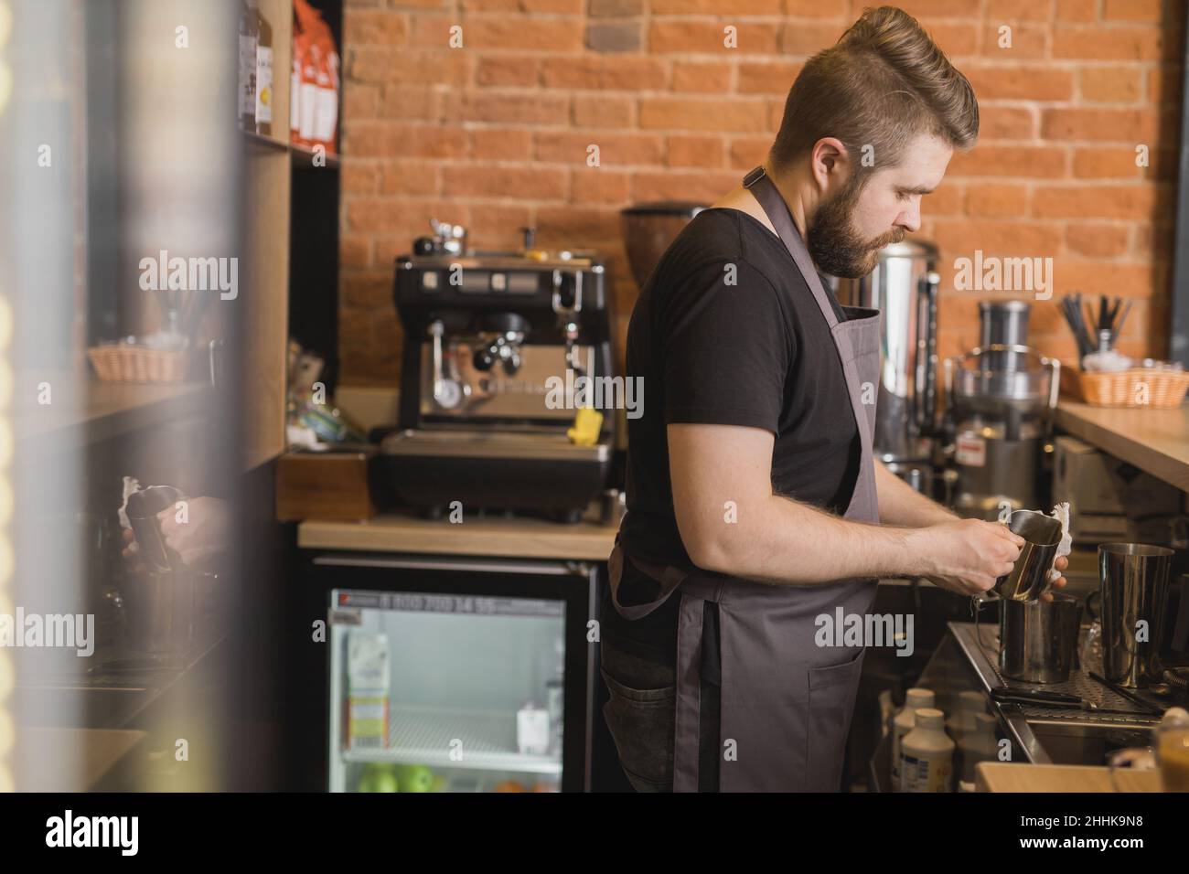 https://c8.alamy.com/compes/2hhk9n8/vista-lateral-de-la-jarra-de-limpieza-barista-masculina-con-servilleta-mientras-esta-de-pie-en-el-mostrador-cerca-de-la-maquina-de-cafe-y-trabajando-en-la-cafeteria-2hhk9n8.jpg