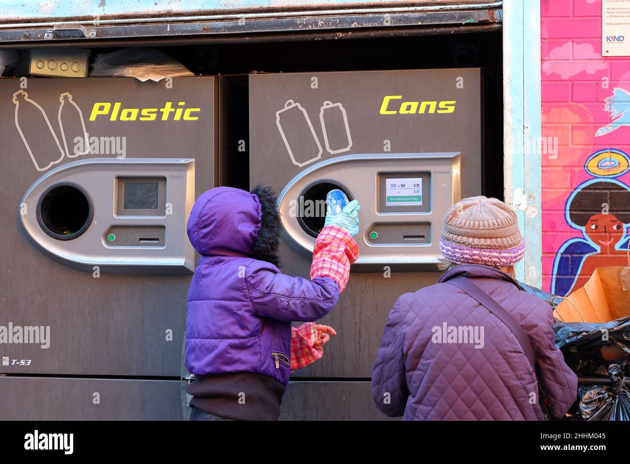 Una persona que usa una máquina expendedora inversa Tomra T-53 para canjear botellas y latas reciclables por su dinero de depósito de botellas en la ciudad de Nueva York. Foto de stock