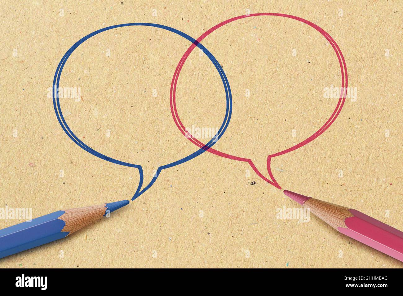 Lápiz azul y rosa con burbujas de voz sobre fondo de papel reciclado - concepto de comunicación entre hombres y mujeres (comunicación de género) Foto de stock