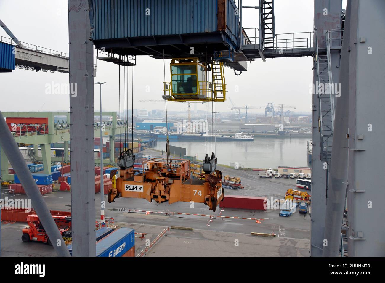 Cabina de control amarilla vacía y esparcidor naranja de la grúa del gantry en el terminal del contenedor en Rotterdam. Foto de stock