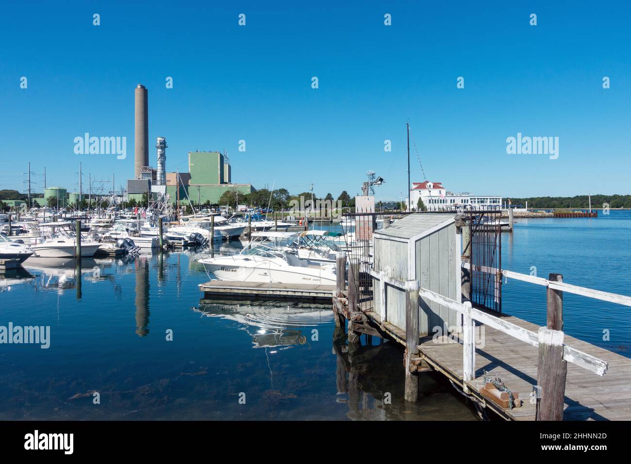 Sandwich Marina en Cape Cod, Massachusetts con muchos barcos atracados y la planta de generación de energía más allá Foto de stock