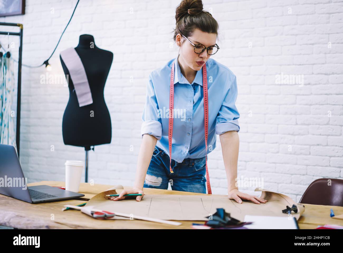 Diseñador de ropa enfocado haciendo dibujos en estudio de moda Foto de stock