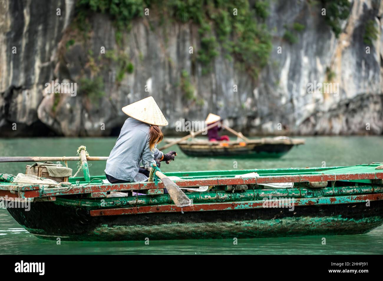 Las mujeres de remo botes de remo de madera Vung Vieng aldea pesquera, la bahía de Ha Long, Bai Tu largo Sector, cerca de Ha Long, Vietnam Foto de stock