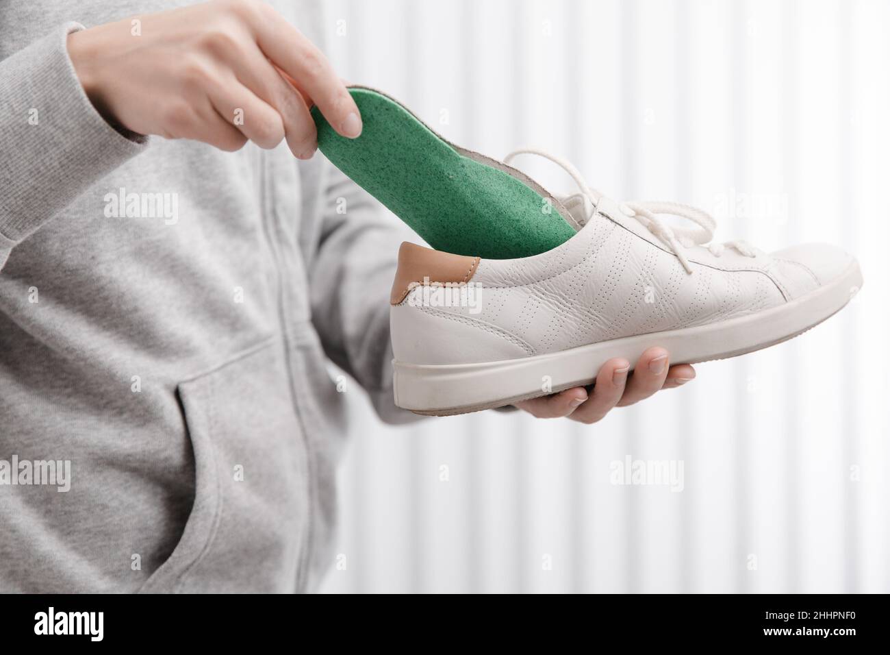 Fitness mujer en ropa deportiva con plantillas ortopédicas y zapatillas de deporte. Mujer poniendo plantilla ortopédica en el zapato en casa de cerca. Banner de cuidado de pies. Plana Fotografía de stock - Fitness mujer en ropa deportiva con plantillas ortopédicas y zapatillas de deporte. Mujer poniendo plantilla ortopédica en el zapato en casa de cerca. Banner de cuidado de pies. Plana Fotografía de stock -