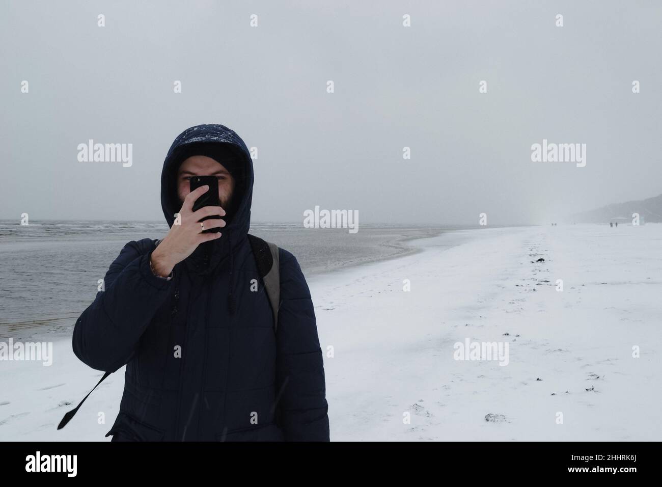 Hombre haciendo una foto de nieve en el mar Báltico Foto de stock