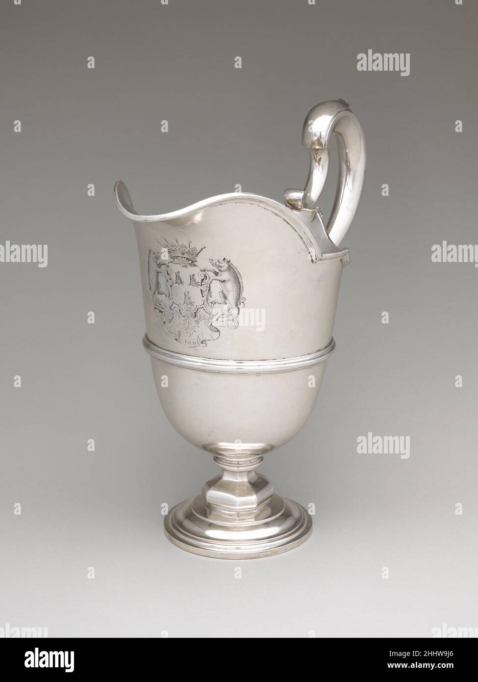 Ewer (uno de un par) 1740/41 Peter Archambo I British Cuando George Booth se convirtió en conde de Warrington a la edad de diecinueve años, heredó la propiedad de Dunham Massey, que estaba muy cargado por la deuda. Pasaron treinta años antes de poder permitirse reconstruir su orgullo familiar comprando plata a gran escala. Este par de oradoras monumentales (véase también 68.141.141) estaba entre la plata que amuebló los diez dormitorios principales de la casa, todos los cuales estaban equipados con suficiente plata para realizar las abluciones matutinas. Ewer (uno de un par) 204943 Foto de stock