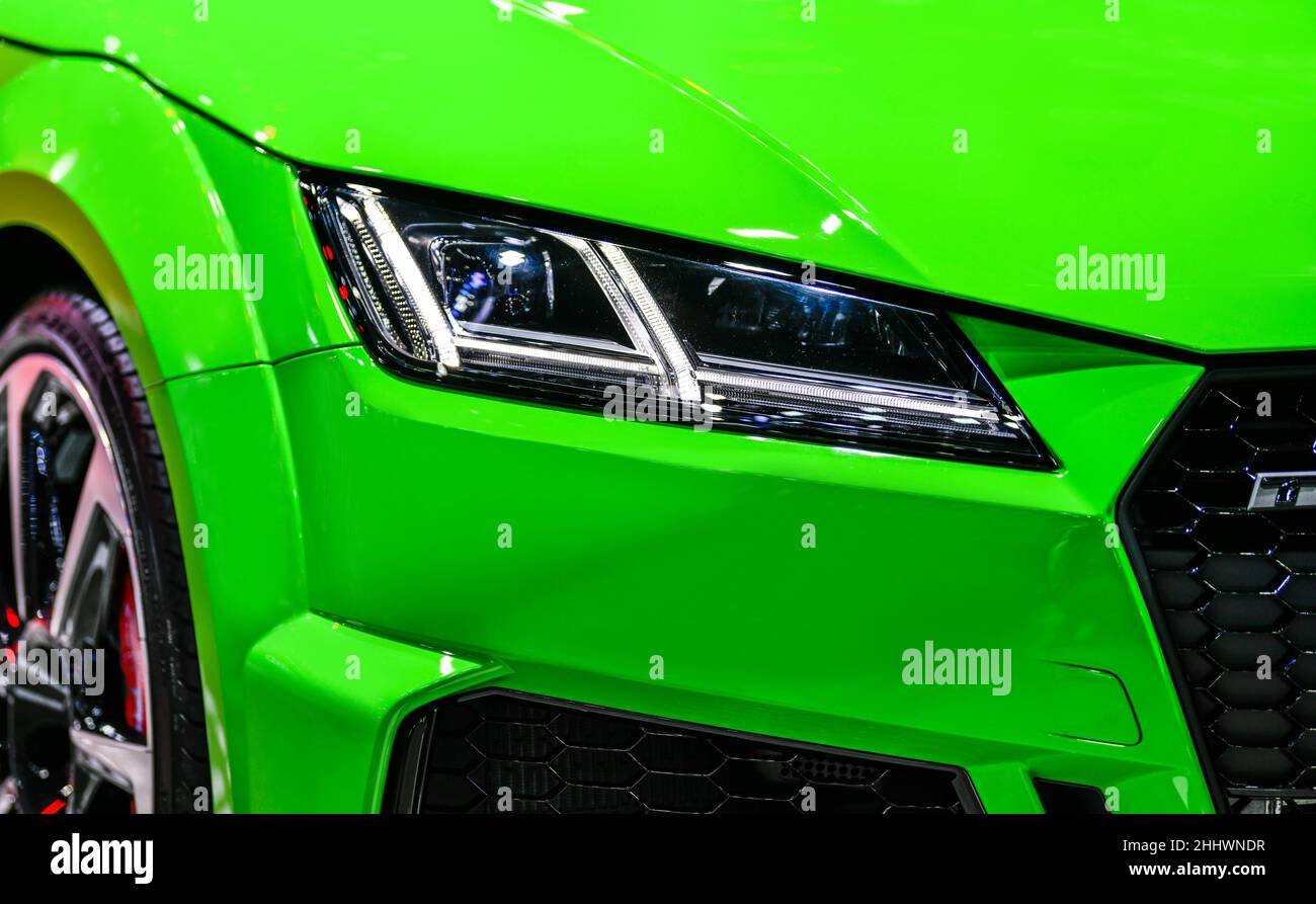 Vista frontal de los faros LED, moderno vehículo verde Foto de stock
