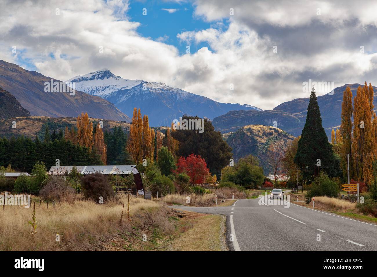 Una carretera rural conduce a las montañas de la región de Otago, Nueva Zelanda. Fotografiado en otoño Foto de stock
