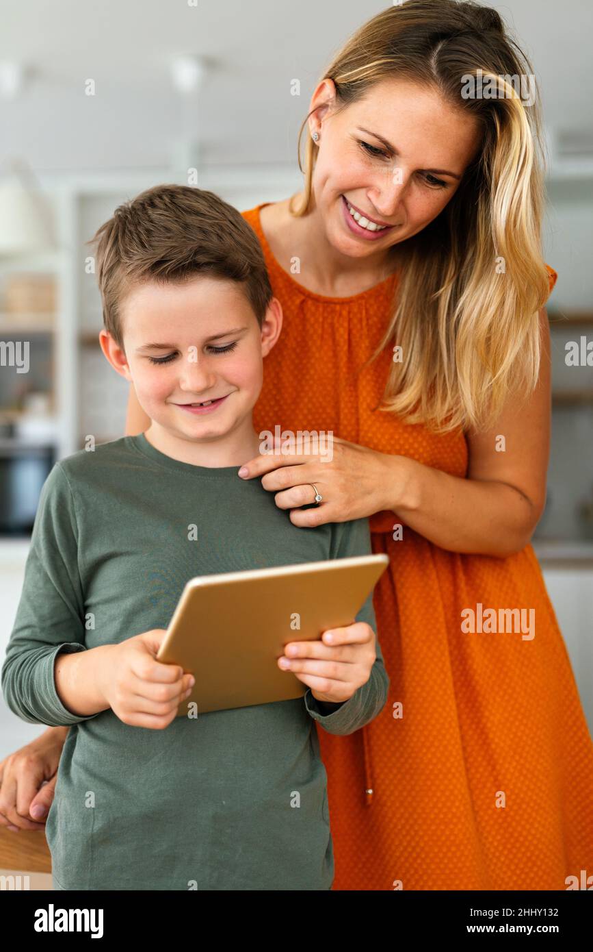 Madre y niño que utilizan tabletas digitales para el aprendizaje electrónico. Concepto de niño de dispositivos digitales para el hogar de la educación. Foto de stock