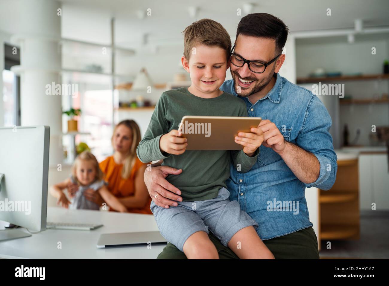 Padre y niño que utilizan la tableta digital para el aprendizaje electrónico. Concepto de niño de dispositivos digitales para el hogar de la educación. Foto de stock