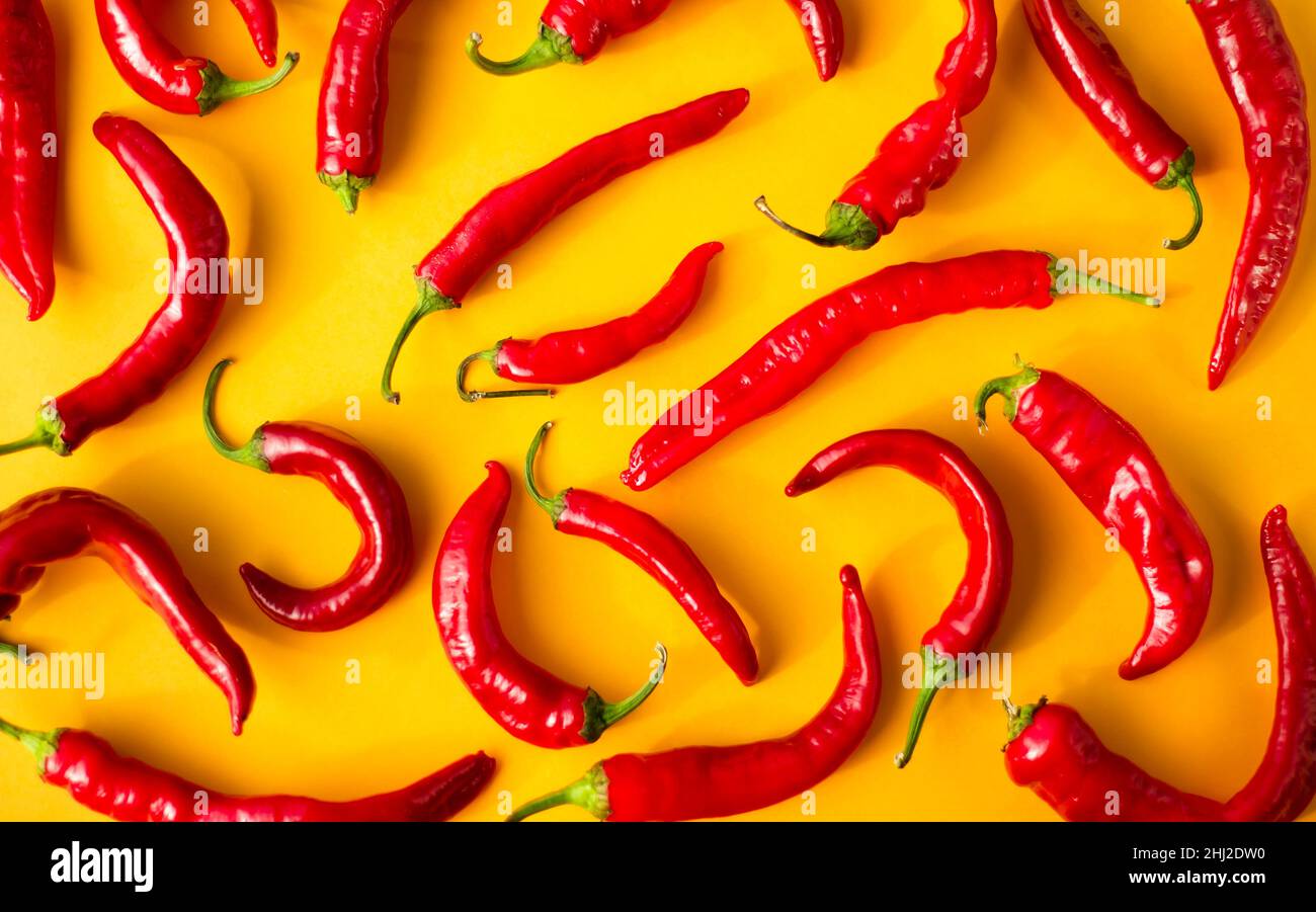 Los fondos son vegetales brillantes. Pimientos calientes rojos sobre fondo amarillo. Chile pimientos. Especias. Foto de stock