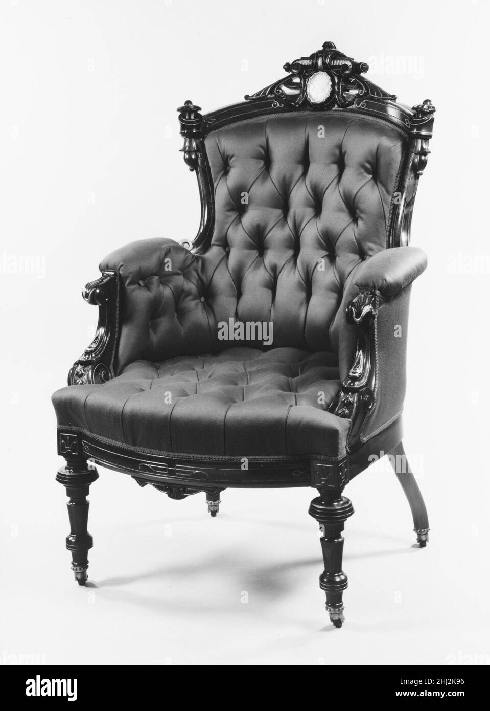 Sillón 1868–70 atribuido a John Jelliff American Este sillón, uno de un par (véase 68.133.3), originalmente amueblado la sala de estar, o salón trasero, de la mansión construida para Jedediah Wilcox en 816 Broad Street en Meriden, Connecticut. Terminada en 1870, la casa fue proclamada como una de las residencias más grandes del estado. Los muebles de palisandro en suite, que incluían un sofá (68.133.1), sillas laterales (68.133.4-.5), un espejo de aumento (68.134.11) y cornisas de ventana (68.134.8-.10), están embellecidos con medallones de nácar con una cabeza de dama de perfil, incisos y dorados Foto de stock