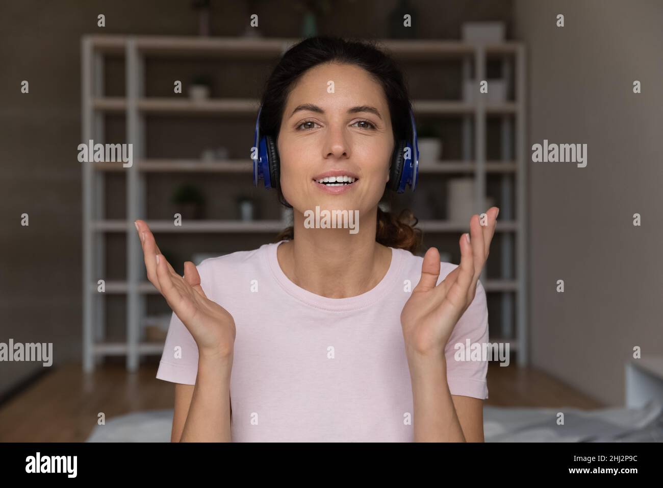 La blogger hispana lleva auriculares se comunica con los suscriptores del canal Foto de stock