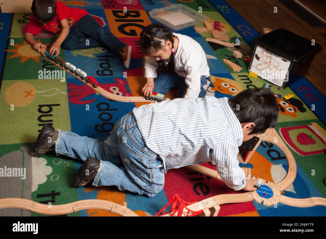 Educación Preescolar 3-4 años Dos niños y una niña jugando con el tren Foto de stock