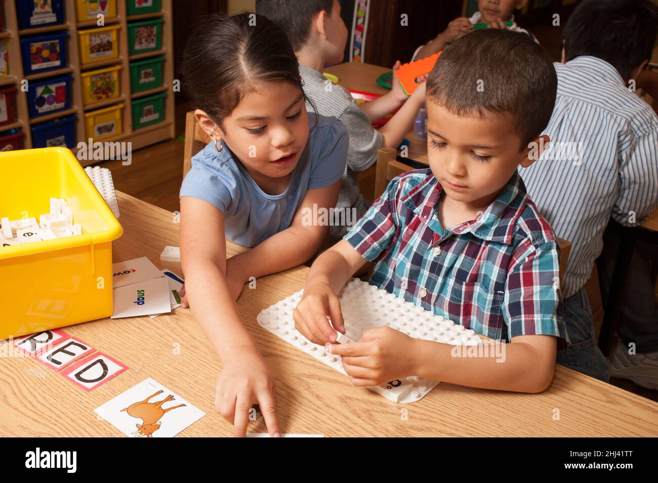 Educación Preescolar Niños de 4-5 años niñas y niños jugando juegos educativos con letras del alfabeto Foto de stock