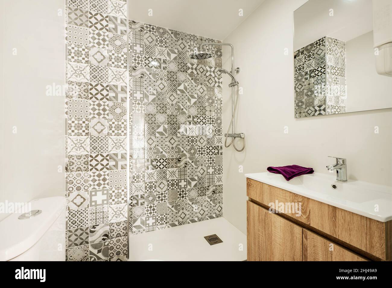 WC con muebles de roble, lavabo de porcelana blanca y pared de ducha con  azulejos hidráulicos grises Fotografía de stock - Alamy
