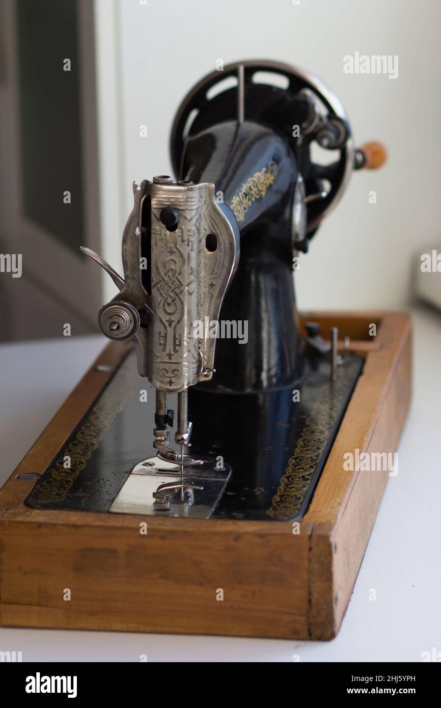 La placa frontal de la máquina de coser manual antigua consiste en un elevador  de barra prensadora, conjunto de tensión de rosca de aguja, pie prensador,  aguja y perro de alimentación Fotografía