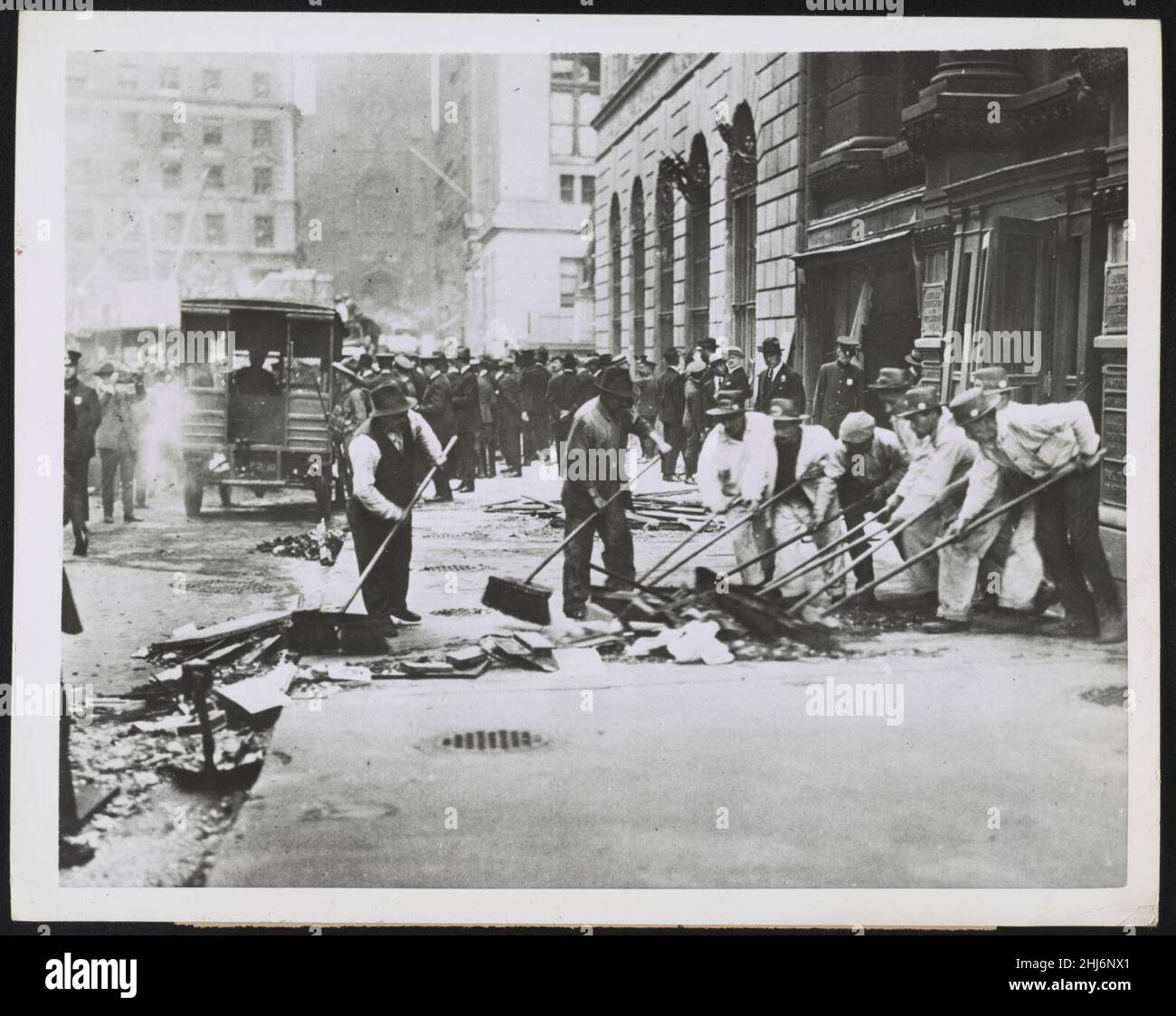 Barriendo los cristales rotos tras Wall St. explosión en 1920, la ciudad de Nueva York Foto de stock