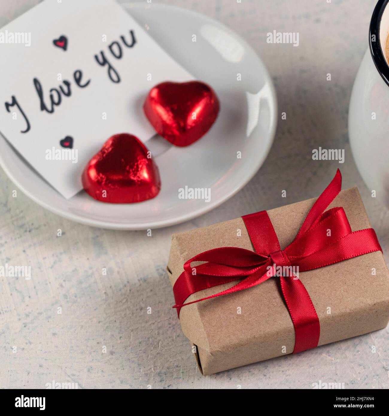 Foto cuadrada con regalo con cinta roja, una taza de café, chocolates en  forma de corazón y una nota con la palabra Te quiero. Desayuno del día de  San Valentín. Concepto del