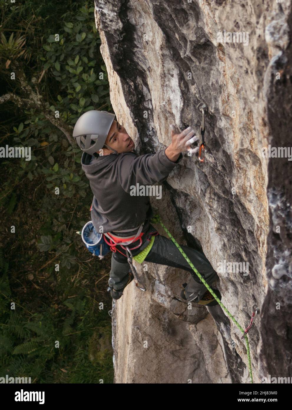 Candid tiro de ajuste oscuro pelado macho de escalada de roca tratando duro Foto de stock