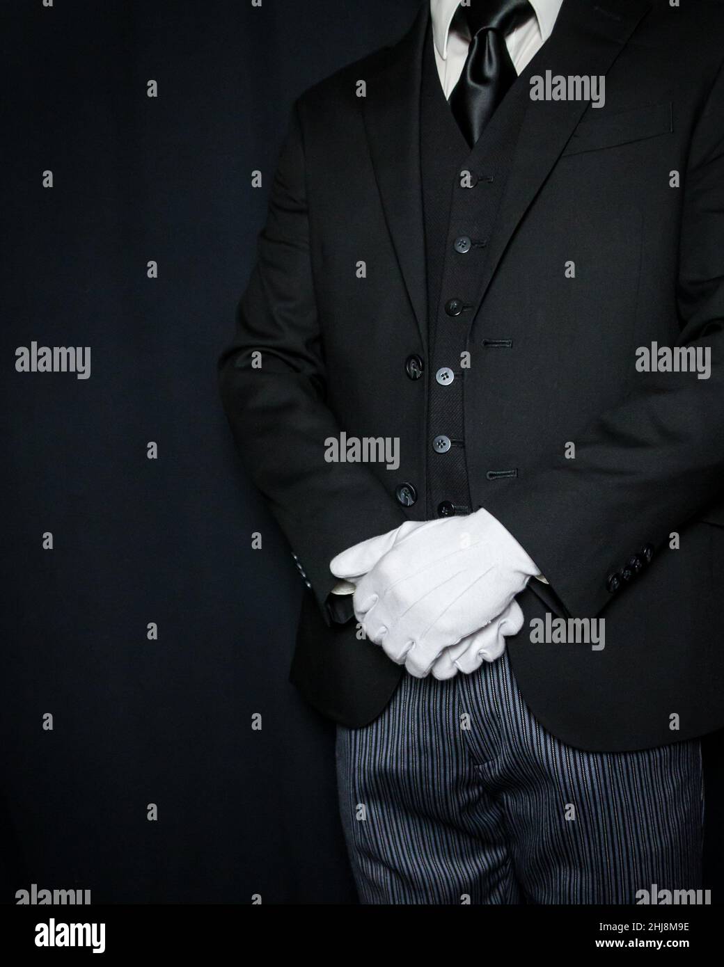 Retrato de mayordomo en atuendo formal y guantes blancos de pie en atención  elegante. A su servicio Fotografía de stock - Alamy