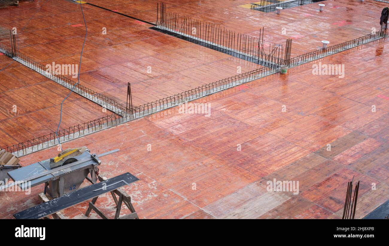 vista sobre un sitio de construcción con el suelo preparado para el llenado de hormigón y una sierra circular de mesa en el borde Foto de stock
