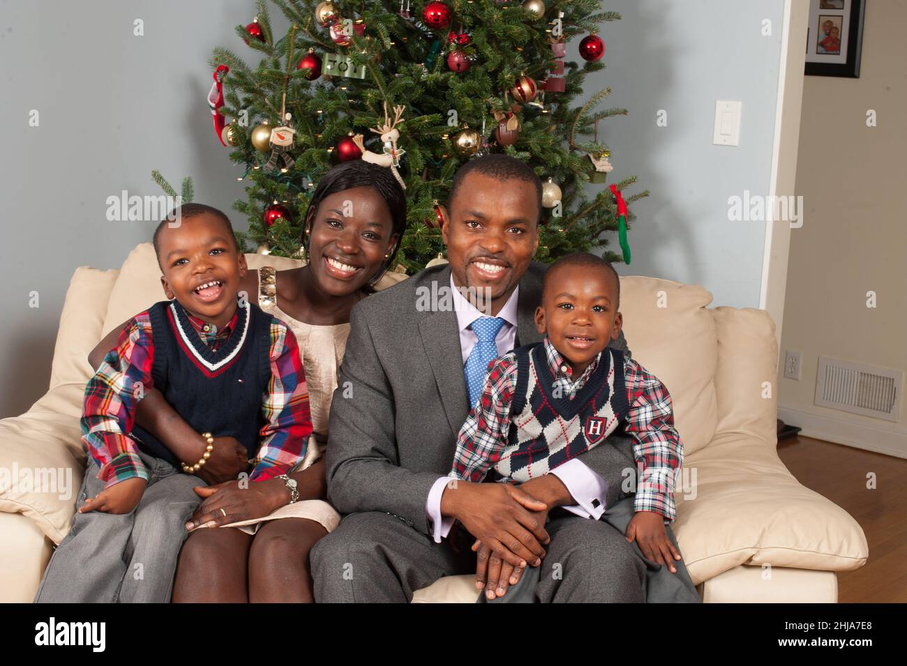 Retrato de familia en casa temporada navideña padres de 30s años con hijos de 2 y 4 años Foto de stock