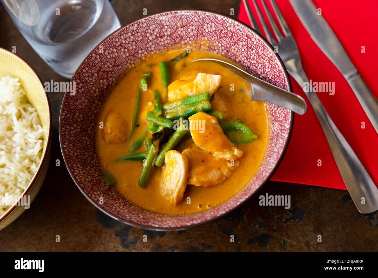 Curry panang de pollo con judías verdes servidas con arroz Foto de stock