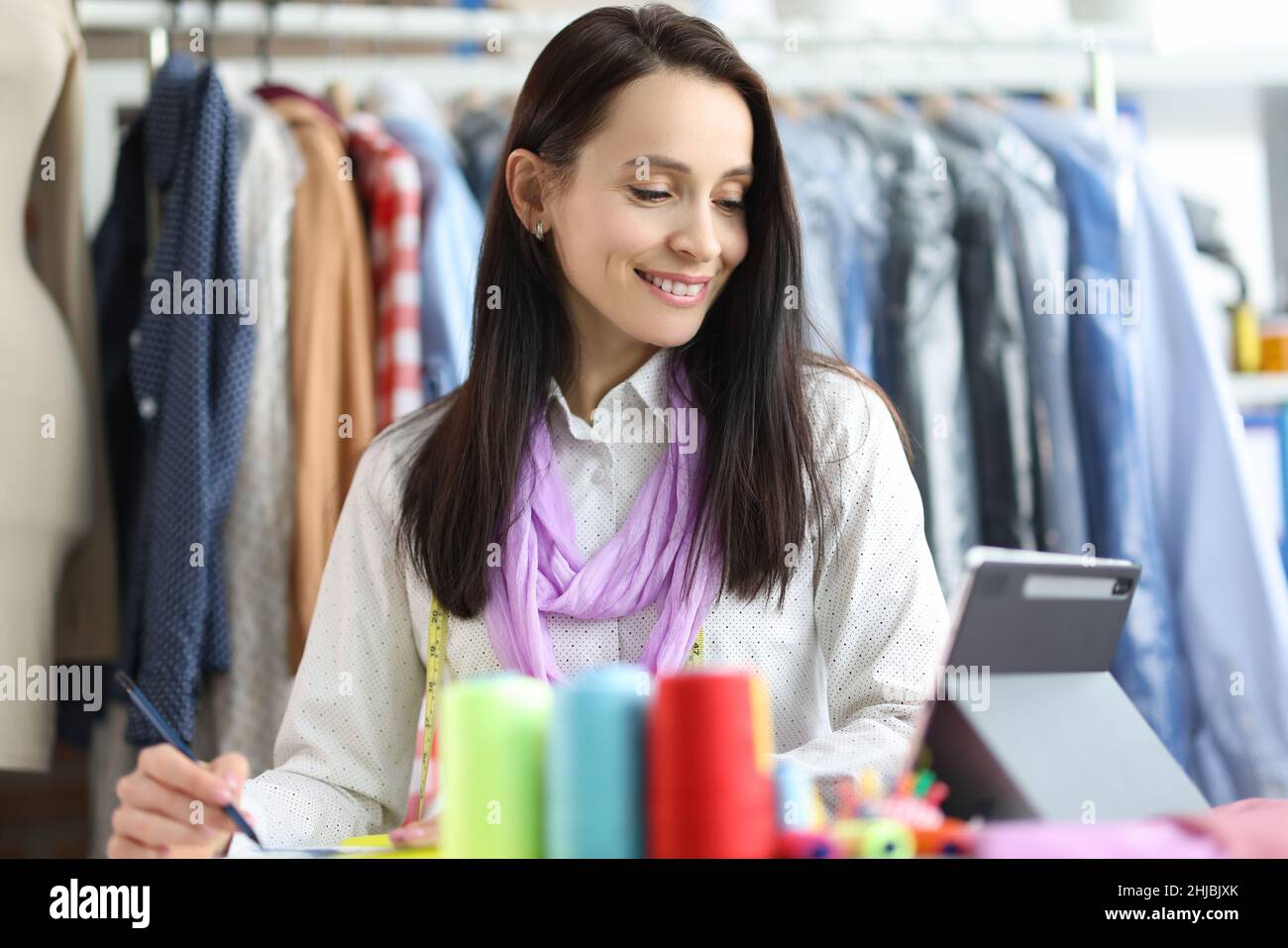 Mujer sonriente estilista diseñadora en el lugar de trabajo en taller Foto de stock