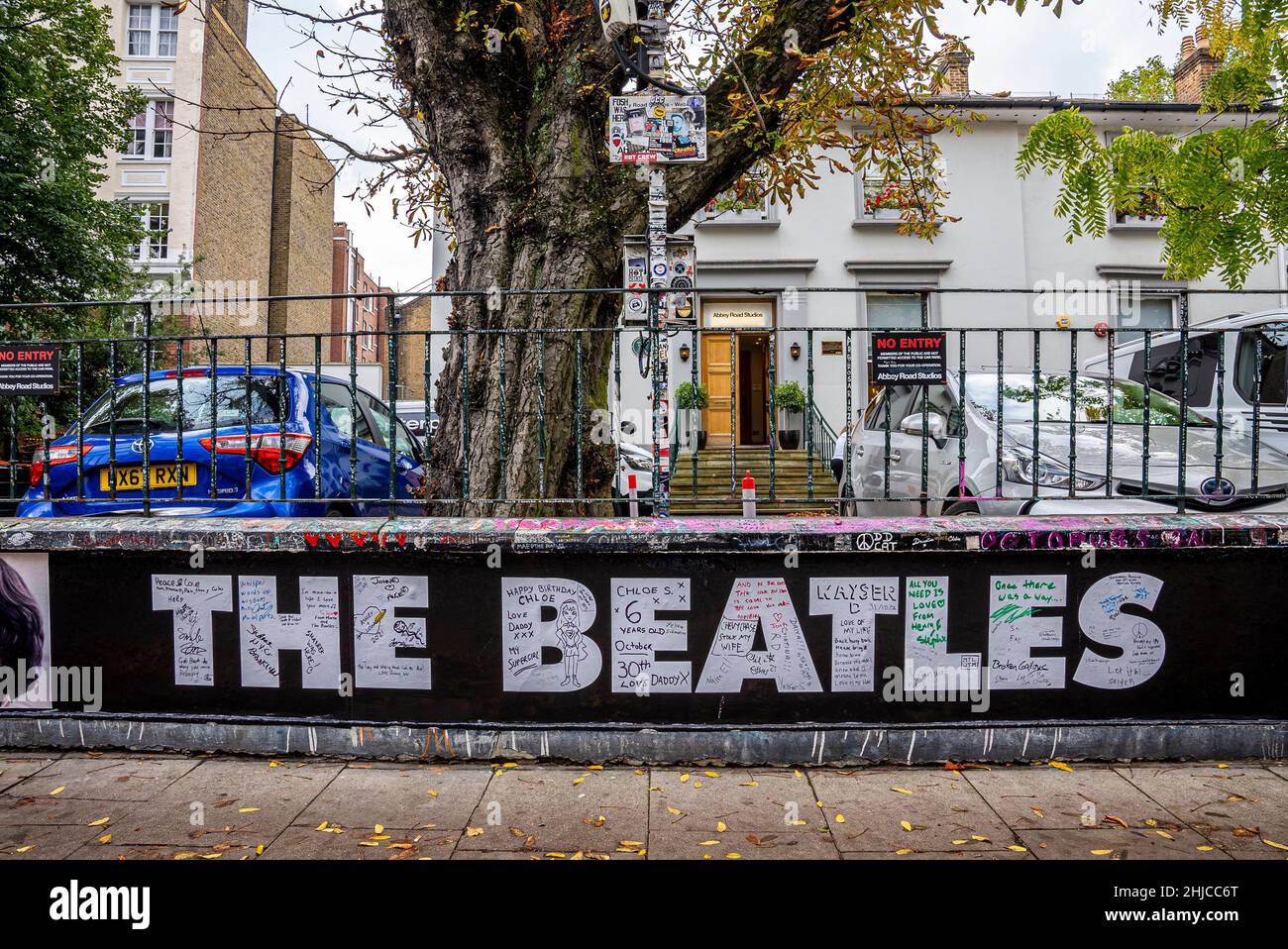 El cartel de los Beatles en Abbey Road en frente de la casa con coches aparcados Foto de stock