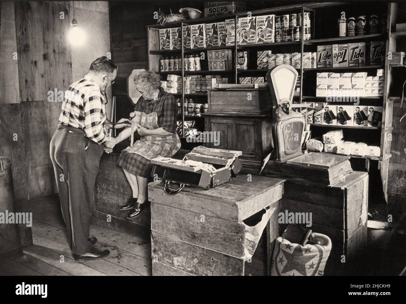El doctor Gaine Cannon hace un chequeo de la presión arterial en uno de sus pacientes en una tienda cerca de Balsam Grove, NC, en 1963. Foto de stock