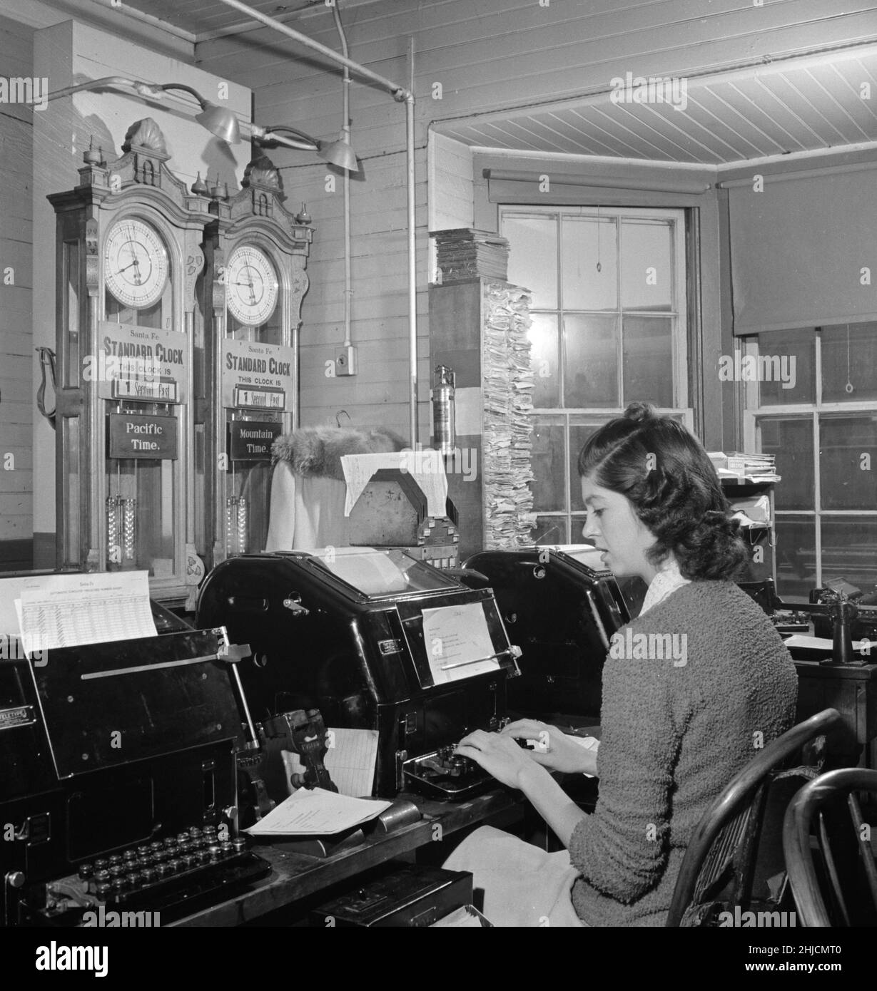 Operador de teletipo en la oficina de telégrafo de Atchison, Topeka y Santa Fe Railroad. El tiempo aquí cambia de la hora de la Montaña al Pacífico,. Fotografiado por Jack Delano, marzo de 1943. Seligman, Arizona. Foto de stock