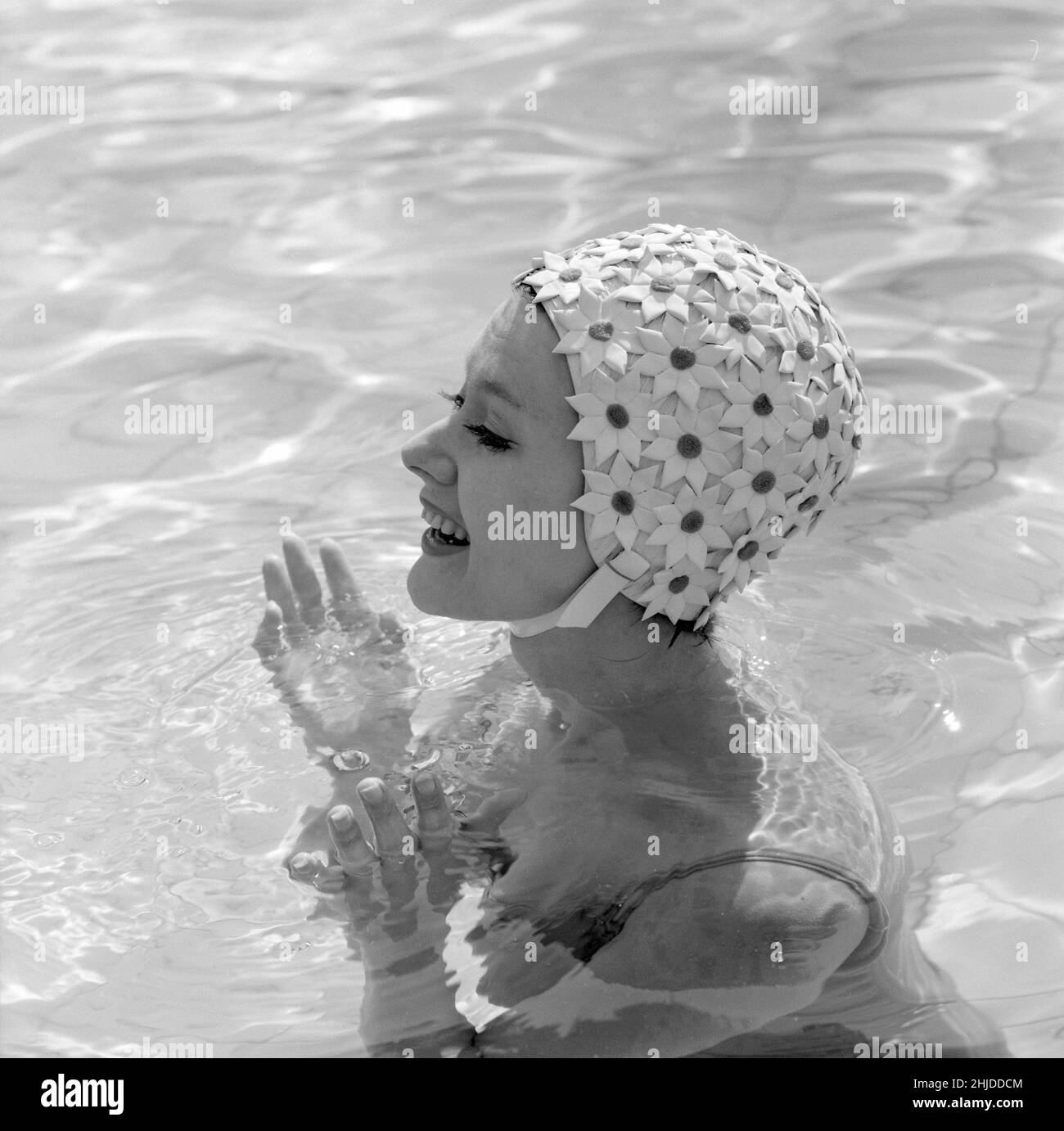 En el 1960s. Una mujer joven fotografiada en la piscina con un típico gorro  de baño de 1960s en un material plástico estampado con flores. SUECIA 1960  Fotografía de stock - Alamy