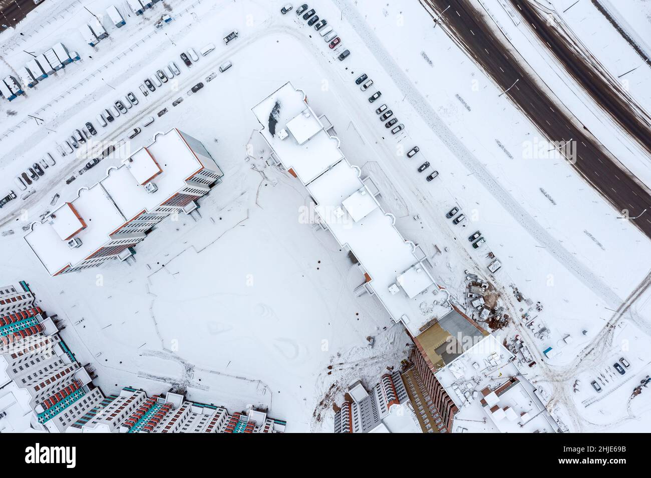 vista aérea del patio de un edificio residencial de gran altura. coches cubiertos de nieve y calles en la ciudad de invierno. Foto de stock