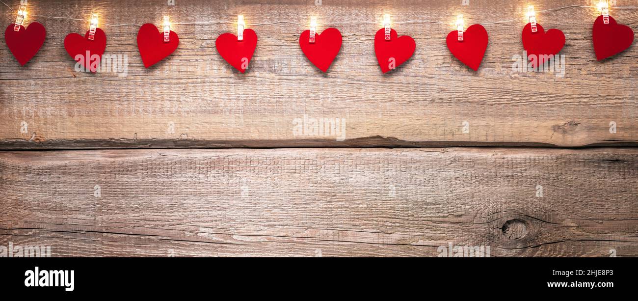 Día de San Valentín copia espacio de fondo con luces de cuerda y corazones de papel en la textura de madera Foto de stock