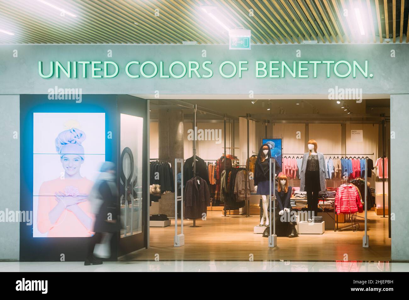 Mujer caminando cerca de United Colors de Benetton Store en las tiendas Centro  comercial Fotografía de stock - Alamy