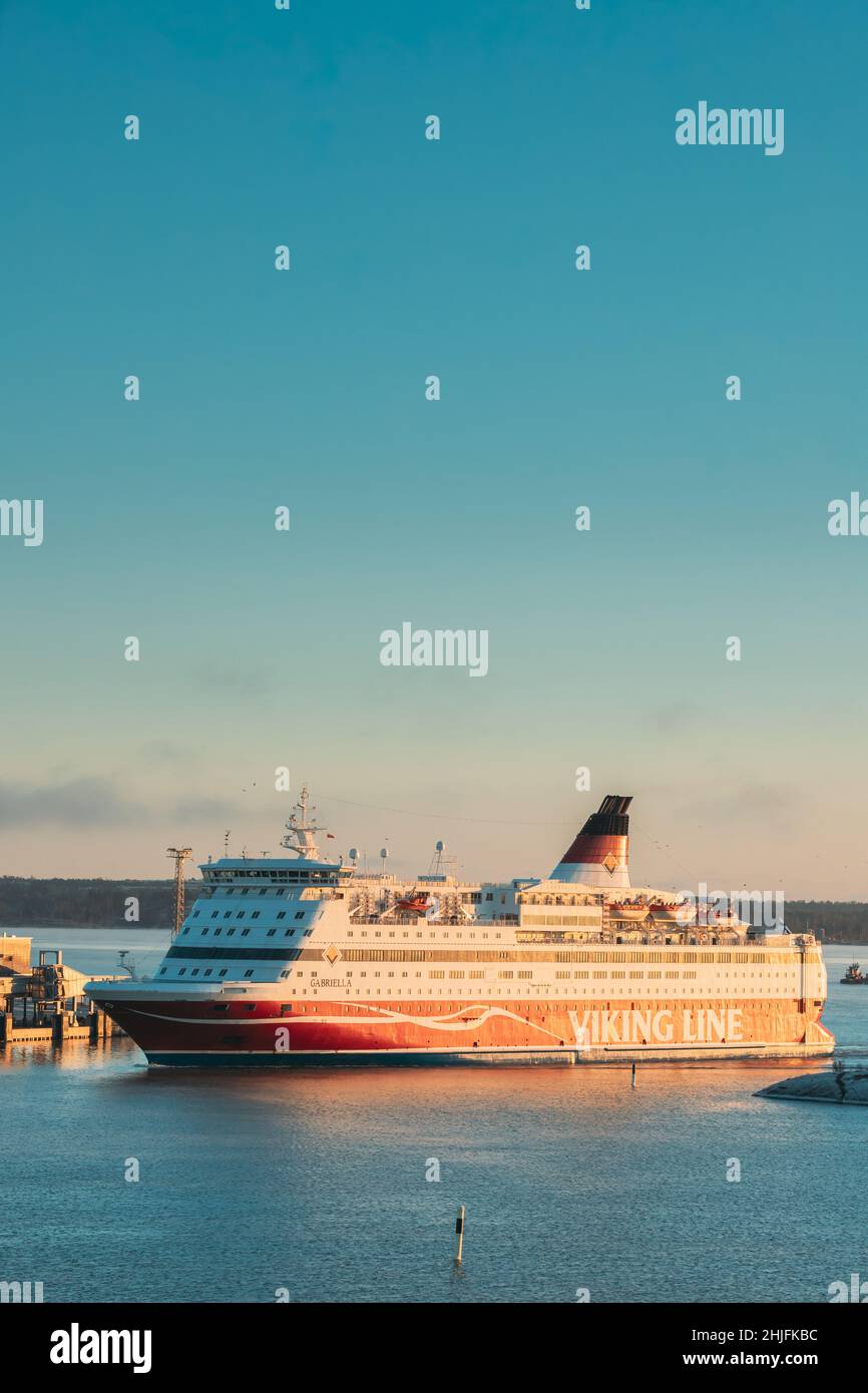 Helsinki, Finlandia. Vista de la moderna línea Viking del ferry que flotan cerca de la isla de Blekholmen Valkosaari en Sunrise Sky. Foto de stock