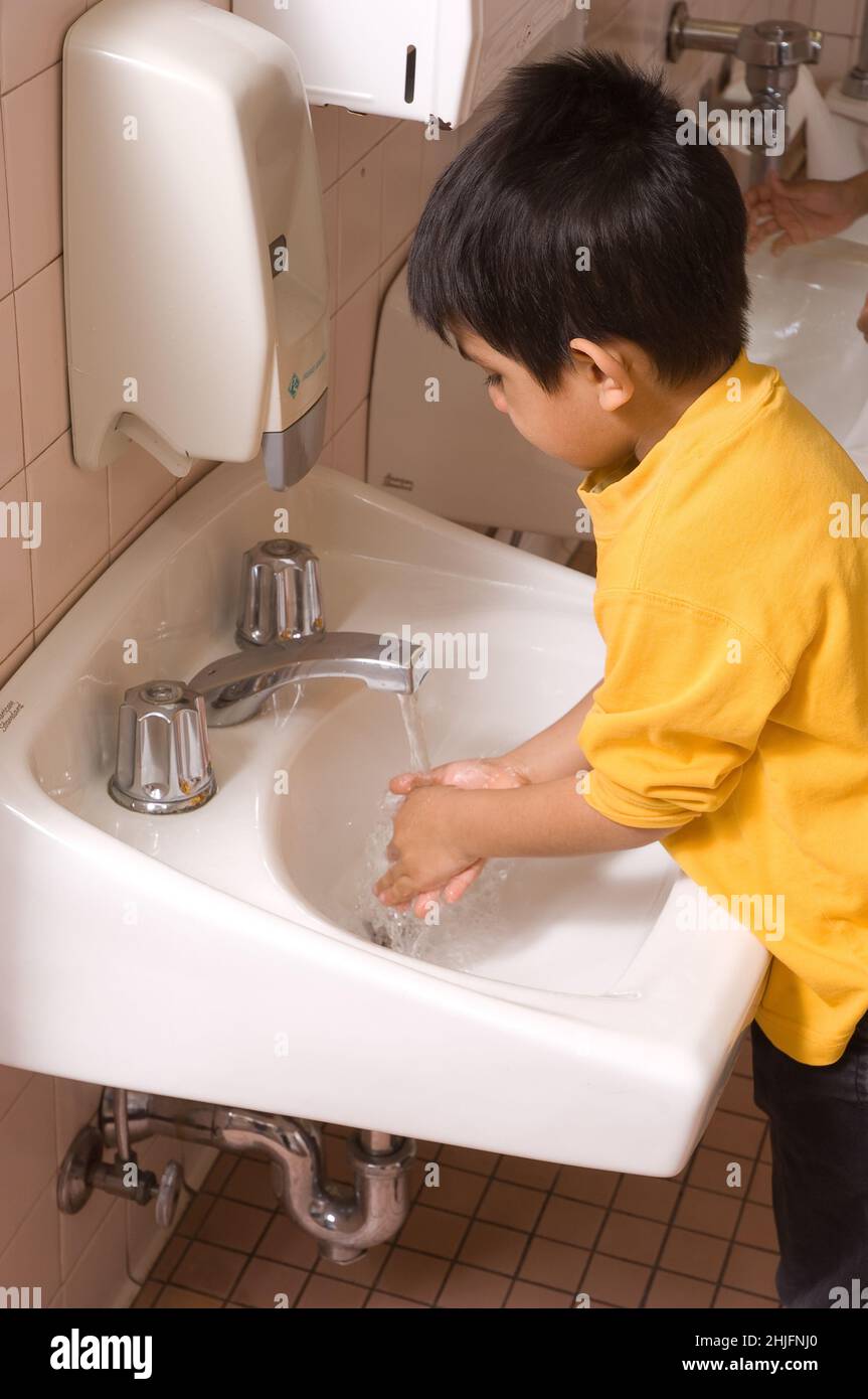 Educación Preescolar edades de 4-5 niños lavándose las manos en el lavabo en el baño Foto de stock
