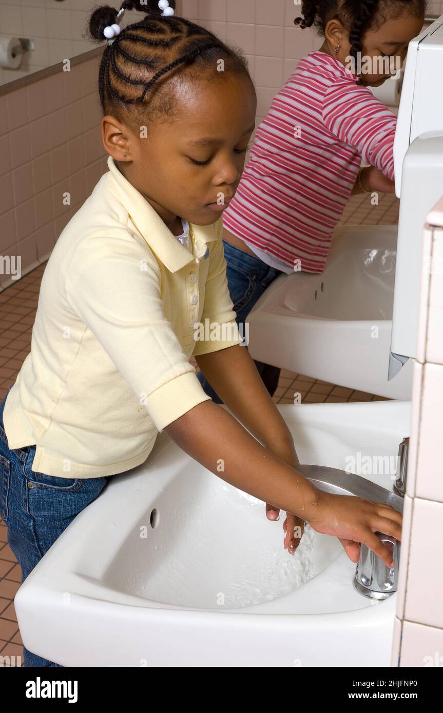 Educación Preschool aula edades 4-5 niña lavando sus propias manos en el lavabo en el baño Foto de stock