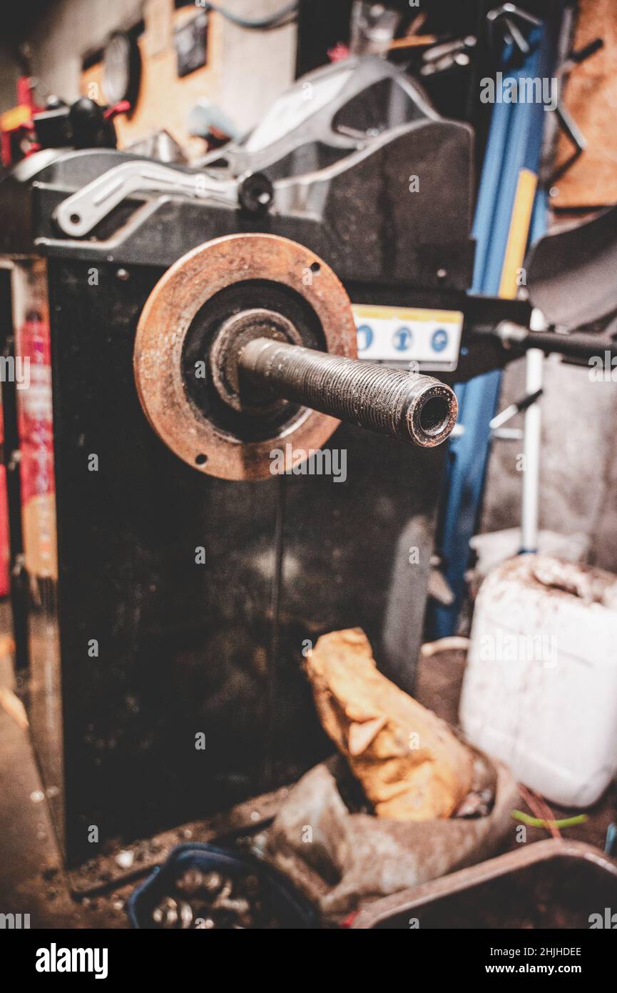 Vertical de un eje de transmisión oxidado antiguo en un taller Foto de stock